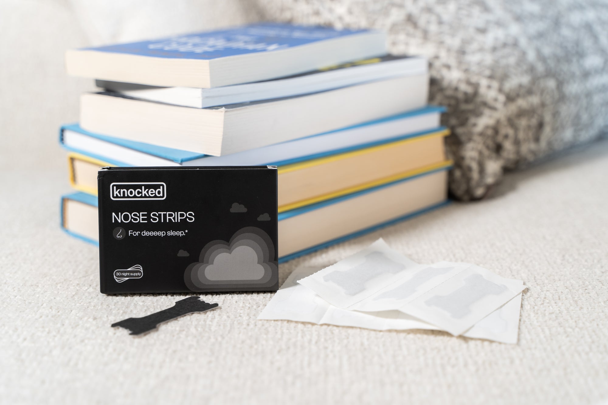 Knocked Nose Strip Package, Nasal Strip, and stack of books